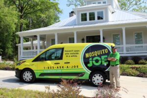 Mosquito Joe Technician standing next to Yellow and Green Service Van.